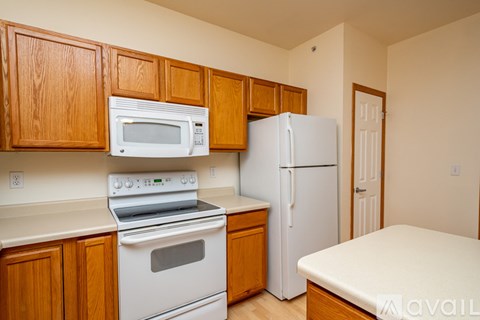 A kitchen with wooden cabinets and a white refrigerator.