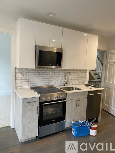 A kitchen with white cabinets and a black microwave above the stove.