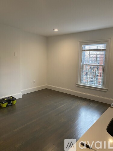 A room with a window and a wooden floor.