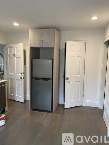 A kitchen with a fridge and a cabinet above it.