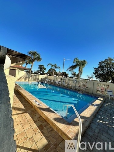 A pool with a tiled edge and a white ladder.
