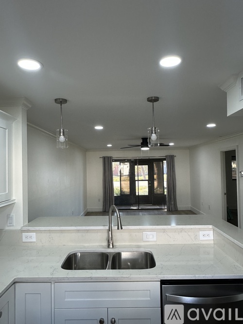 A kitchen with a sink and a fan on the ceiling.
