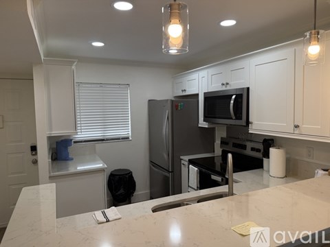 A kitchen with a sink and a fan on the ceiling.