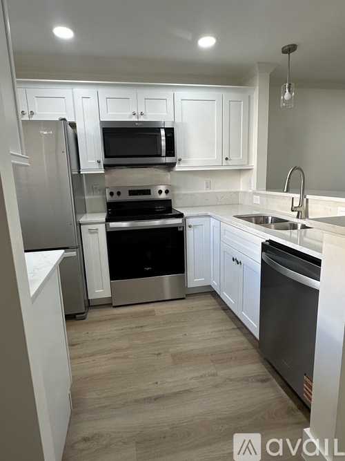 A kitchen with white cabinets and stainless steel appliances.