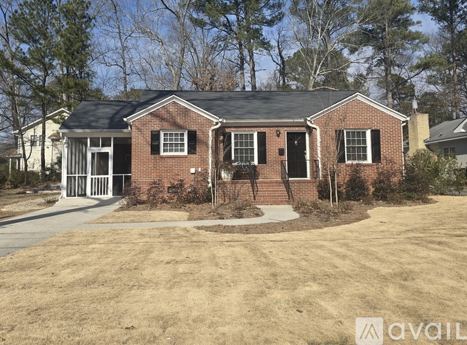 A house with a driveway and trees in front.