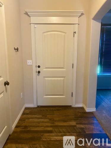 A white door with a black handle and a small window to the right.