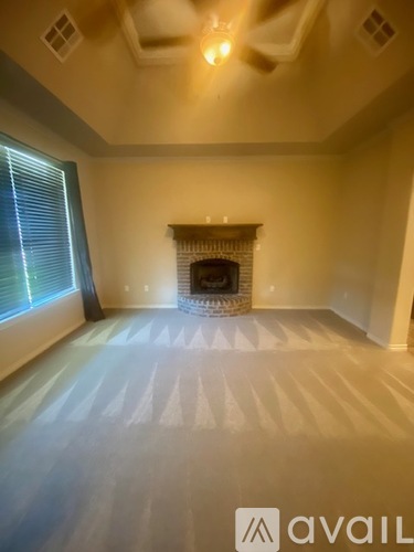 A room with a fireplace and a window with blinds.