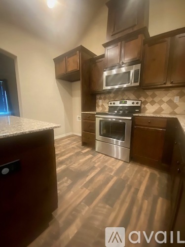 A kitchen with wooden cabinets and a stainless steel oven.