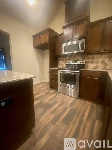 A kitchen with wooden cabinets and a stainless steel oven.