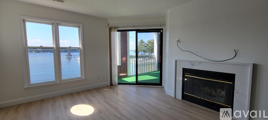 A living room with a fireplace and a view of the water.