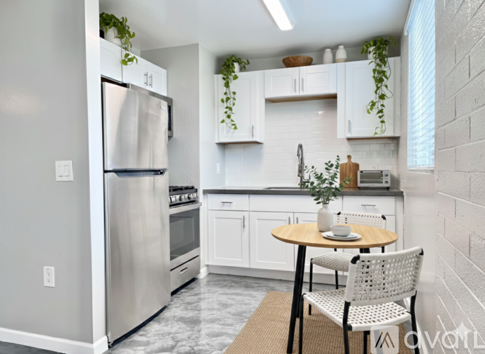 A kitchen with a table and chairs and a refrigerator.