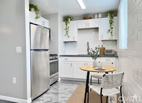 A kitchen with a table and chairs and a refrigerator.
