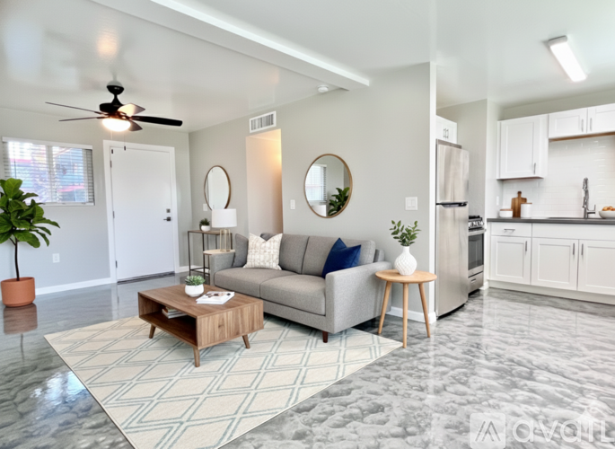 A modern living room with a grey couch, a wooden coffee table, and a ceiling fan.