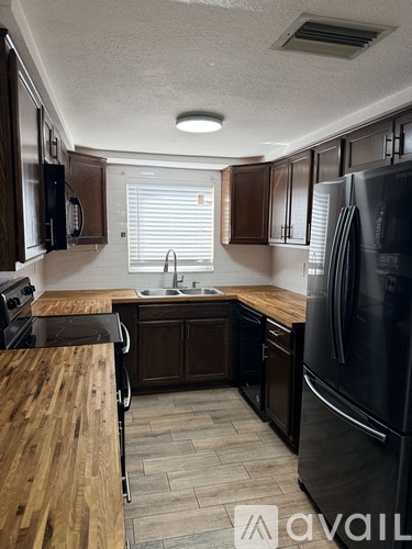 A kitchen with a dining table and chairs in the foreground.