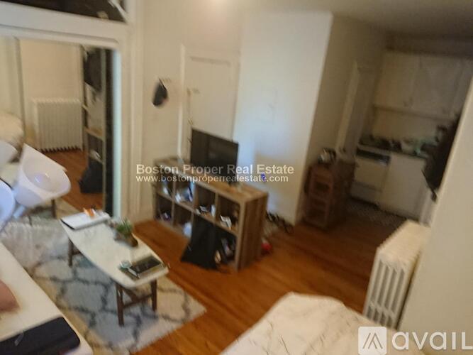 A living room with a couch, coffee table, and a television.