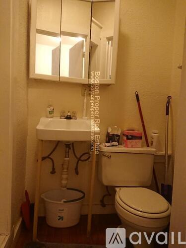 A small bathroom with a toilet, sink, and a mirror.