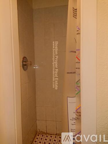 A bathroom with a shower and a sign that says "Boston Proper Real Estate".