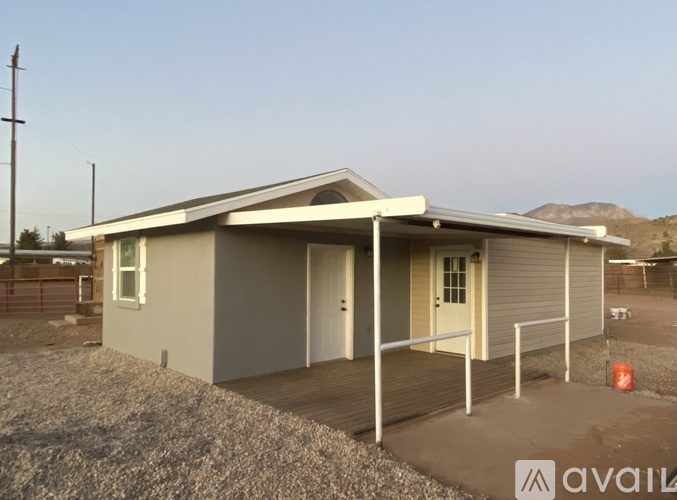 A house with a grey roof and a white door is available for purchase.