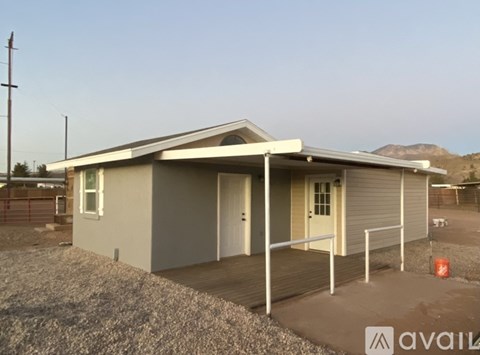 A house with a grey roof and a white door is available for purchase.