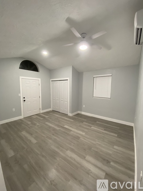A room with a ceiling fan and two doors.