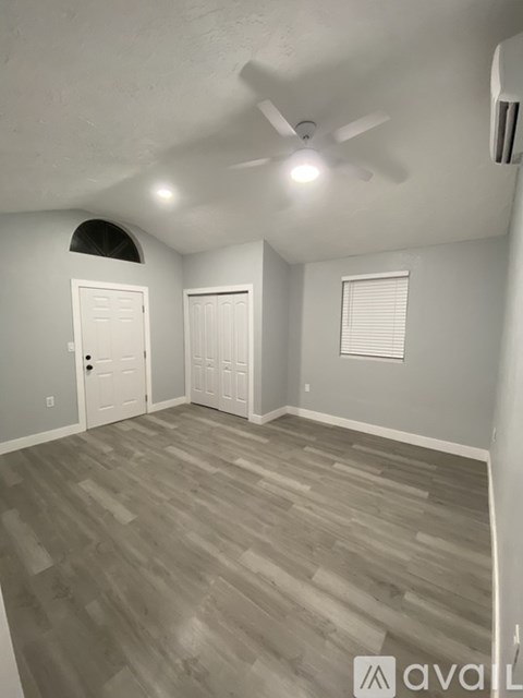 A room with a ceiling fan and two doors.