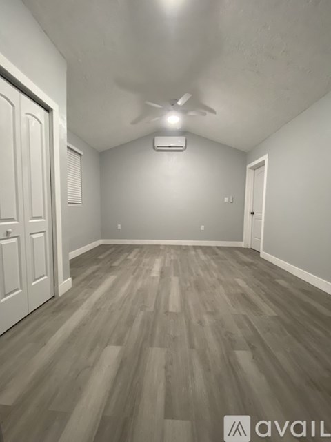 A room with wooden flooring and a ceiling fan.