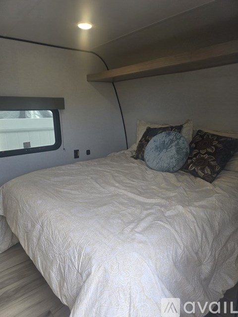 A small bedroom with a bed and a bench seat.