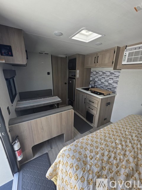 A compact RV kitchen with a sink, stove, and counter space.