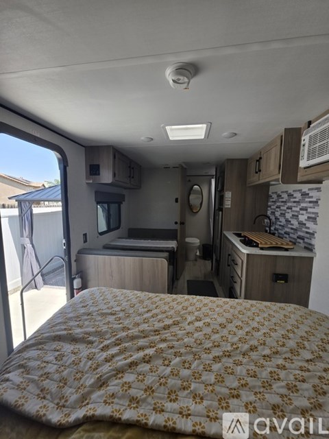 A bedroom with a bed, a microwave, and a window.