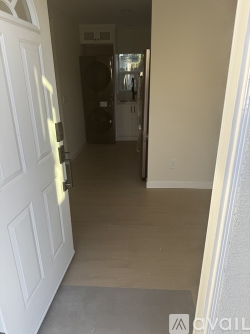 A small house with a white door and a window with a black frame.