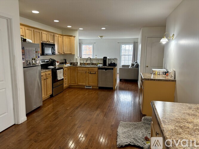 A kitchen with wooden floors and a refrigerator.