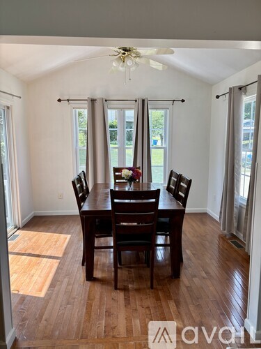 A dining room with a wooden table and chairs.