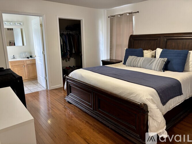 A bedroom with a large bed and a wardrobe.