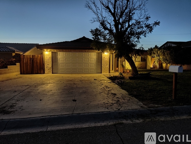 A house with a lit garage door at dusk.