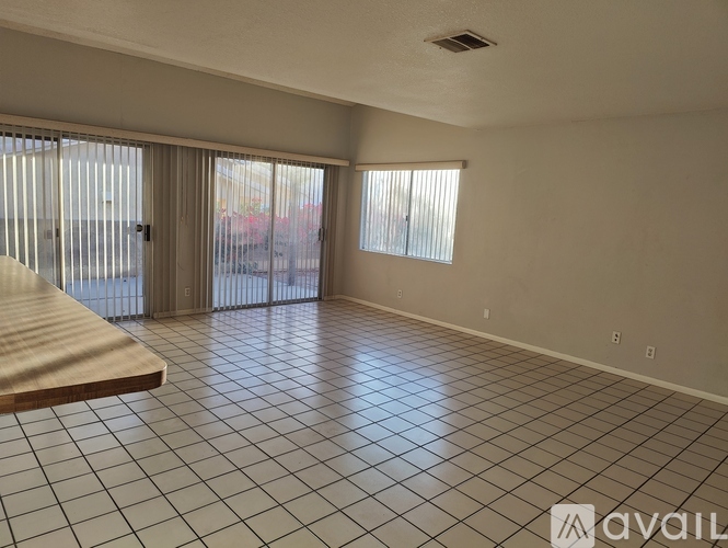 A spacious room with tiled flooring and sliding glass doors.