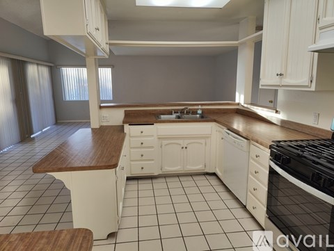 A kitchen with white cabinets and a black stove top oven.