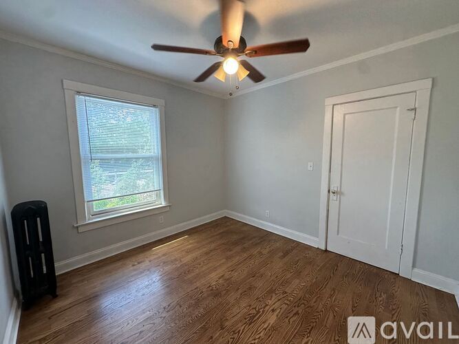 A room with a ceiling fan and wooden flooring.