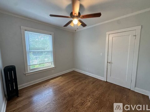 A room with a ceiling fan and wooden flooring.
