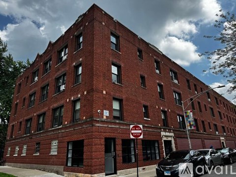 A red brick building with a no parking sign in front.