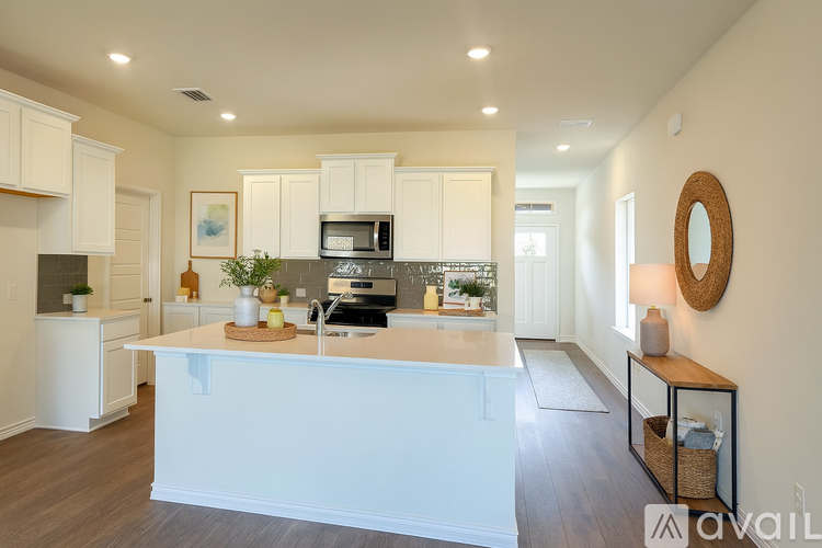 A kitchen with white cabinets and a wooden island.