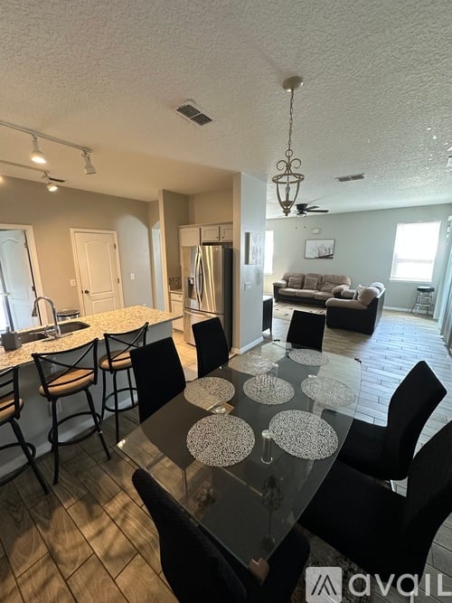 A dining room with a glass table and chairs.
