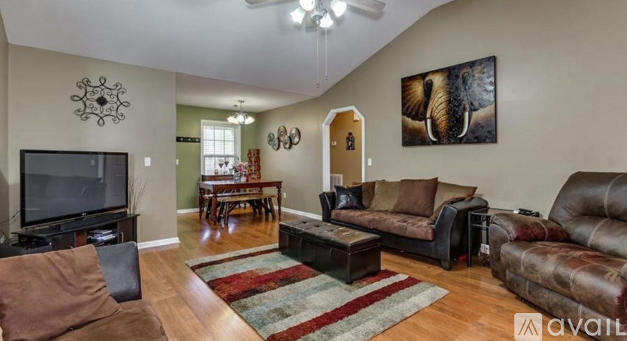 A living room with a brown leather couch and a television.
