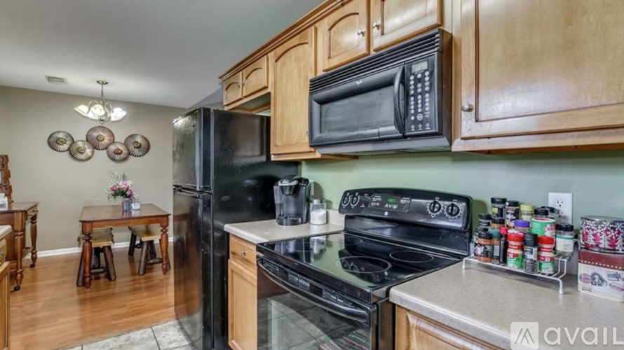 A kitchen with wooden cabinets and black appliances.