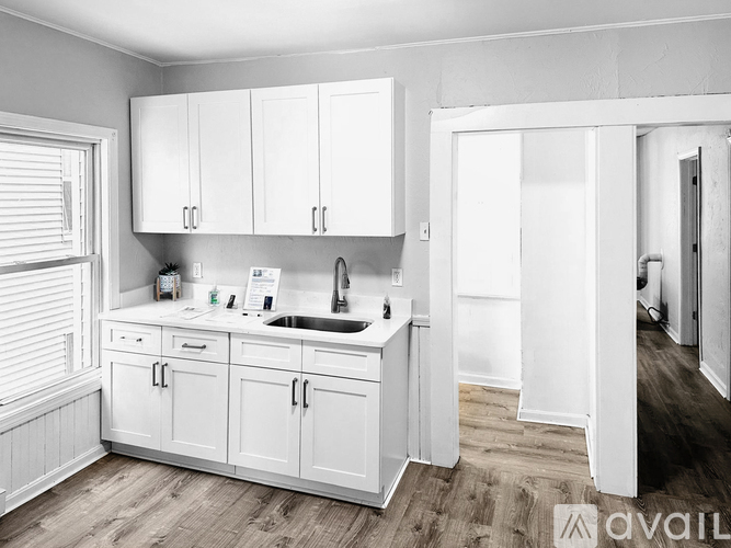 A kitchen with white cabinets and a sink.