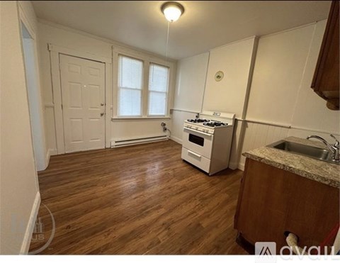 A kitchen with a stove, sink, and cabinets.