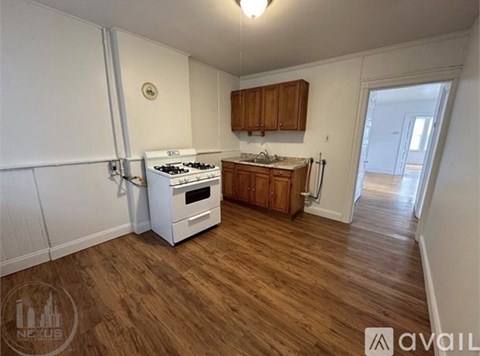 A kitchen with a white stove and wooden cabinets.