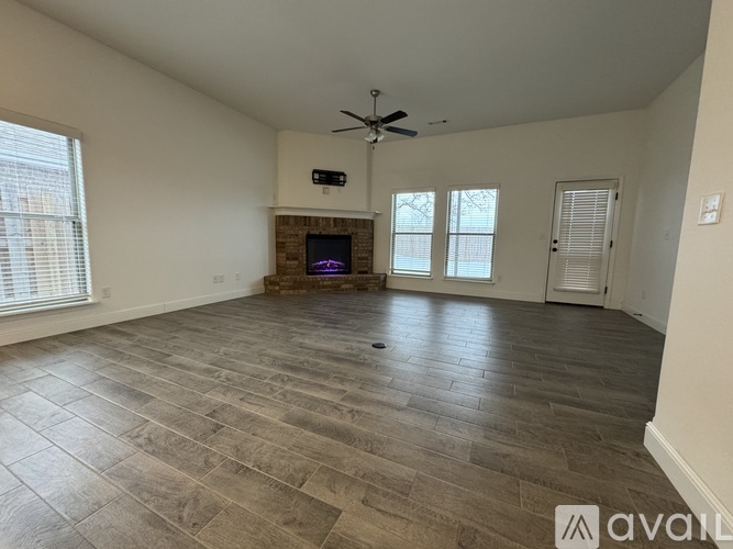 A spacious living room with a fireplace and a television.