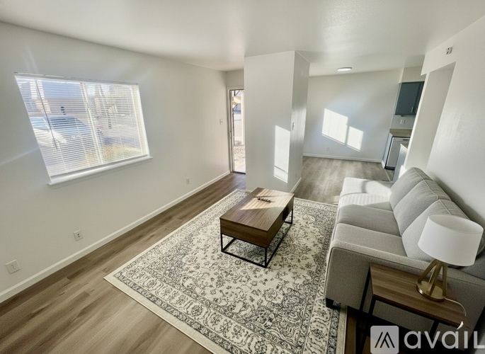 A living room with a couch, coffee table, and rug.