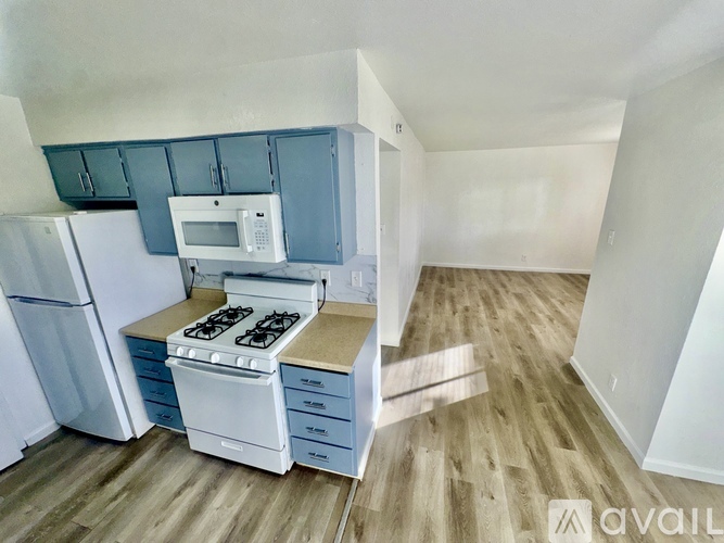 A kitchen with a white stove top oven and a white microwave above it.