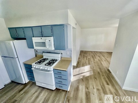 A kitchen with a white stove top oven and a white microwave above it.